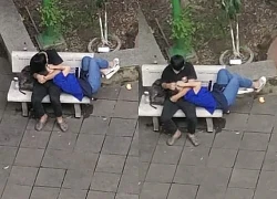 Carefree student couple lying on each other&#39;s lap, hugging and touching in public